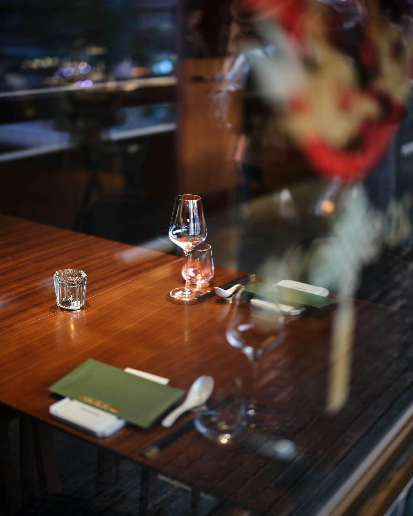Ein elegant gedeckter Restauranttisch am Fenster, abends